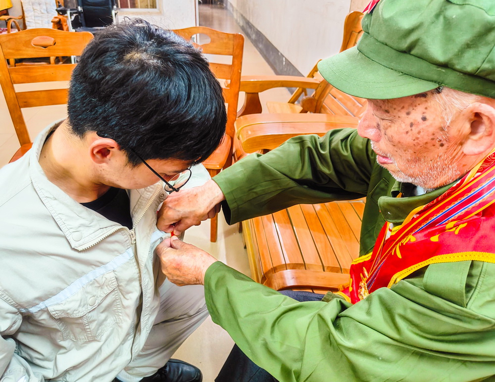 2、韋仕隆給新入黨的青年黨員佩戴黨章--李陽(yáng)攝.jpg